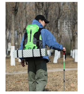 Outdoor hiking backpack featuring a sleeping pad attachment and trekking pole support