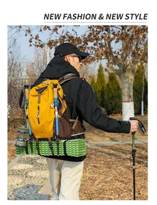 Outdoor 40L hiking backpack in yellow with trekking poles and camping gear attached