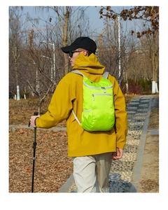 Outdoor waterproof folding backpack in neon green shown during a hiking trip