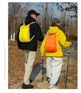 Outdoor hikers wearing lightweight water-resistant backpacks in vibrant yellow and orange