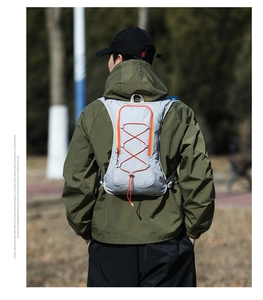 Lightweight grey running vest with orange bungee cords on a male athlete outdoors