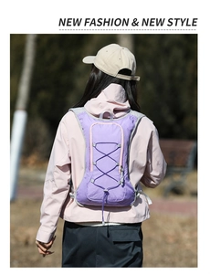 Outdoor hydration backpack in purple fabric shown on a model during a mountain run