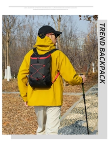Outdoor foldable hiking backpack in black and red worn by a hiker on a forest trail