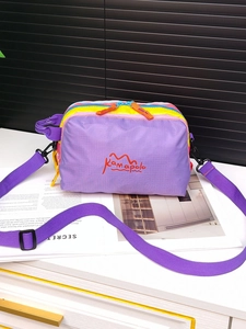 Close-up of multicolor waterproof crossbody bag with purple nylon and adjustable strap