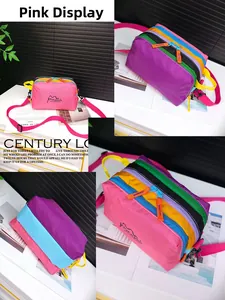Detail view of multi-color patchwork nylon crossbody bag with pink strap and zip compartments