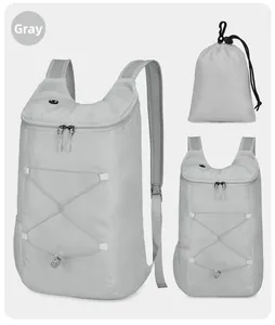 Detail of lightweight gray foldable hiking backpack showing ripstop fabric and storage pouch