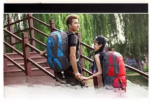 Outdoor scene of blue and red large capacity hiking backpacks worn by hikers on a trail