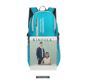 Detail view of the lightweight blue foldable backpack compared with an A4 magazine