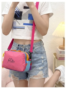 Detail shot of multi-color crossbody bag with pink nylon panels and kamapolo logo
