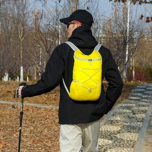Bright yellow foldable outdoor hiking backpack with adjustable white bungee cords
