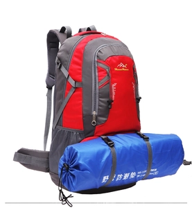 Detail view of hiking backpack with blue camping mat attached to the bottom via straps