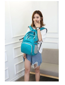 Detailed view of the turquoise waterproof nylon foldable backpack with side mesh pockets