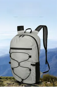 Detail of light grey foldable hiking backpack with breathable mesh straps and bungee cord