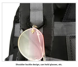 Detail of the shoulder strap buckle on a hiking backpack with hanging sunglasses