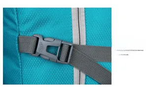 Detail of durable plastic buckle and tear-resistant fabric on turquoise folding backpack