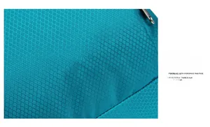 Macro shot of teal diamond-pattern ripstop nylon fabric with metal zipper detail