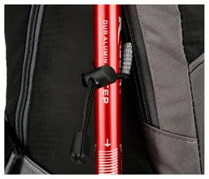 Detail of outdoor backpack side bungee cord system securing a trekking pole on ripstop fabric