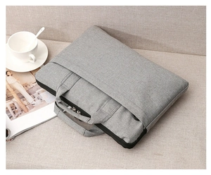 Detailansicht graue Laptoptasche auf weichem Hintergrund mit Kaffeetasse und Magazin