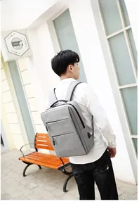 Grey business laptop backpack with USB port and multiple zippered pockets on the side
