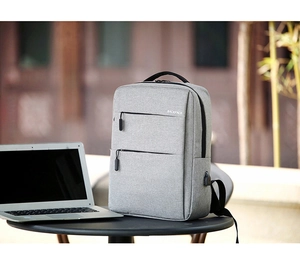 Side view of gray business laptop backpack with external USB port on a table