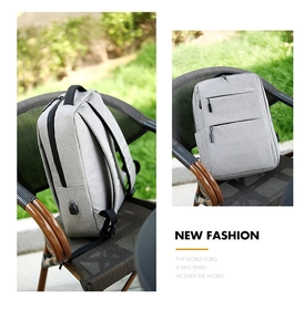 Grey business backpack detail showing USB charging port and Oxford fabric texture