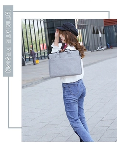Graue Laptoptasche im minimalistischen Business-Stil von einem Modell in der Hand getragen