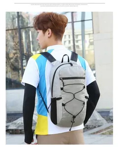 Close-up of light grey outdoor backpack featuring elastic bungee cord and mesh straps