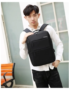 Front view of black durable polyester commuter backpack worn by male model in daily scene