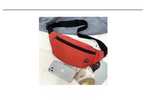 Größenvergleich der roten Nylon-Bauchtasche neben einem Smartphone auf Denim-Hintergrund
