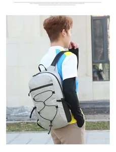 Outdoor shot of light gray sports backpack with bungee cord system and nylon fabric