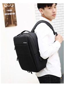 Detail of black business backpack featuring integrated USB charging port and multiple zippers