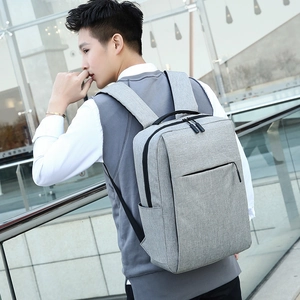 Modern grey laptop backpack with USB port shown in an urban business setting