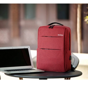Close-up of red business laptop backpack showing the side USB charging port and texture