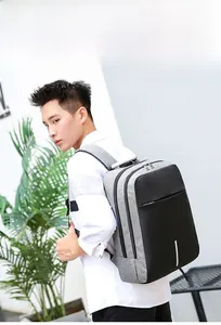 Seitenansicht des grauen Business-Rucksacks aus Stoff und Leder getragen von einem Modell