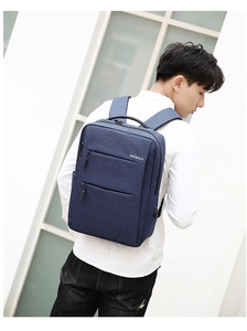 Detail of navy blue business backpack featuring multi-layer zipper pockets and water-resistant fabric