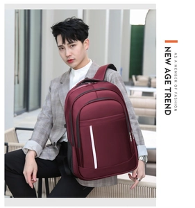 Outdoor street view of burgundy business laptop backpack with white reflective stripe