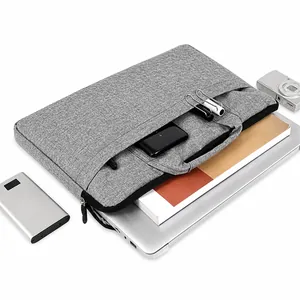 Gros plan d'une housse d'ordinateur grise avec fente avant pour téléphone et stylos