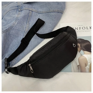 Détail du sac banane noir avec fermeture éclair en métal, trou pour écouteurs et sangle