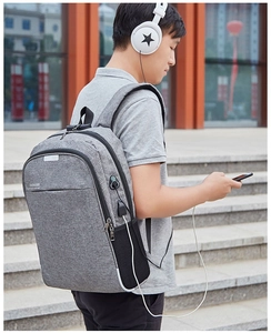 Détail montrant le port de charge USB intégré sur le côté du sac à dos d'affaires gris