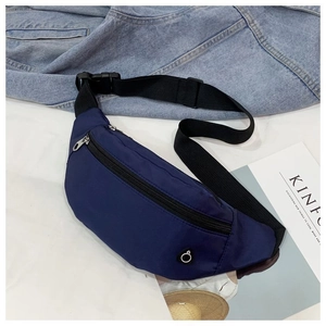 Détail de la sacoche banane en nylon bleu marine avec sangle ajustable sur fond en jean