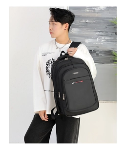 Detalle de la mochila negra impermeable con bolsillo lateral y etiqueta deportiva roja
