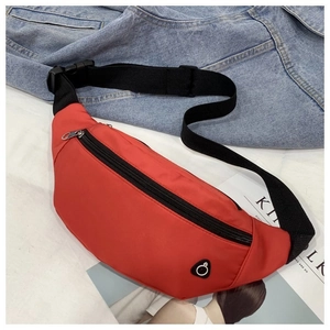 Détail du sac banane en nylon rouge avec sangle réglable sur fond de magazine lifestyle