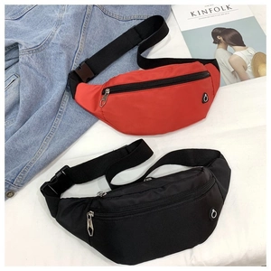 Détail des sacs banane en nylon rouge et noir avec sangles réglables et logo circulaire