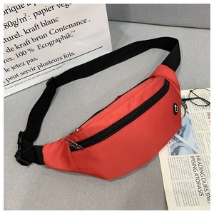 Détail du sac banane en nylon rouge avec double fermeture éclair et sangle réglable