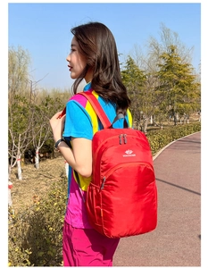 Detail of red waterproof outdoor backpack featuring Vanaheimr logo and side mesh pocket