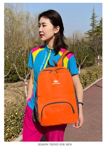 Zaino sportivo arancione brillante in nylon impermeabile indossato da un modello