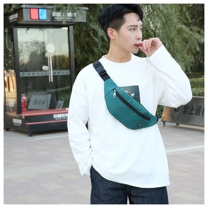 Détail d'un sac banane en nylon vert foncé avec sangle réglable porté par un homme