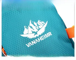 Détail du tissu en nylon ripstop sarcelle avec logo montagne blanc et sangle orange
