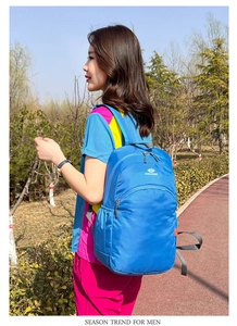 Detail of blue waterproof travel backpack with adjustable straps and sturdy top handle
