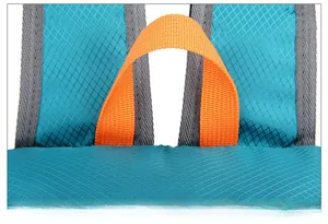 Détail macro du tissu en nylon bleu ciel avec poignée renforcée orange sur sac à dos outdoor